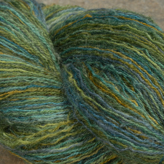 Monet's Pond Coopworth Lace Yarn. Yarn is variegated blues, greens, and highlights. 
